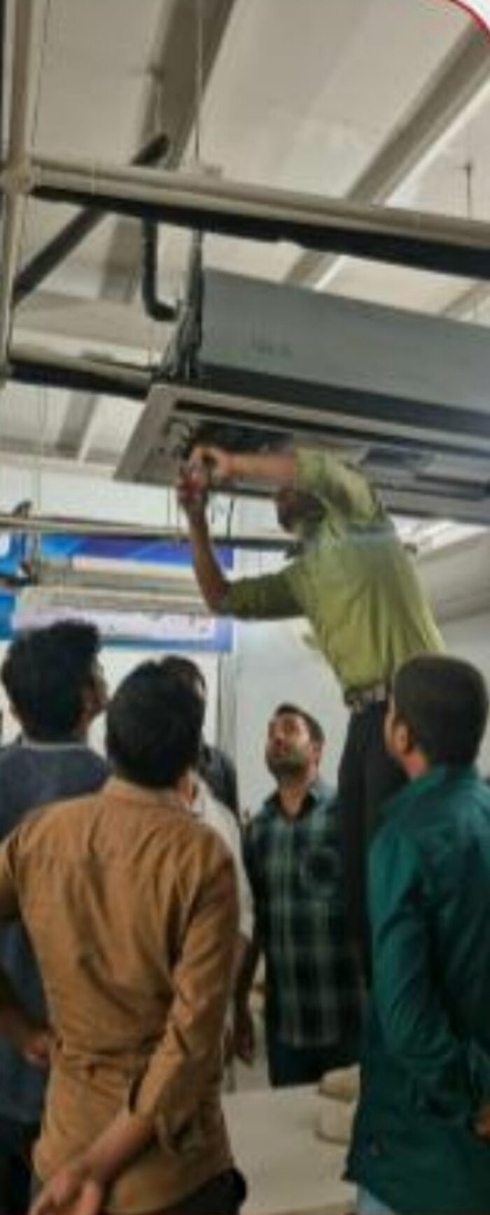 Trainer demonstrating ducted AC servicing to students